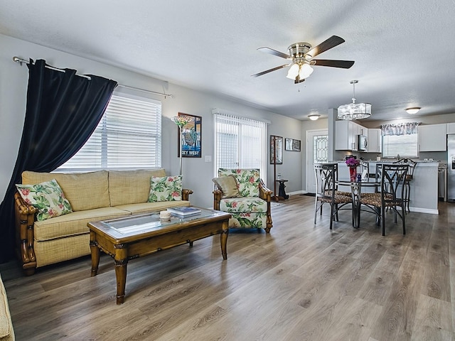 1722 Moreno Pl, The Villages, FL 32159 - living area featuring ceiling fan, healthy amount of natural light, light wood-style floors, a textured ceiling, and a chandelier