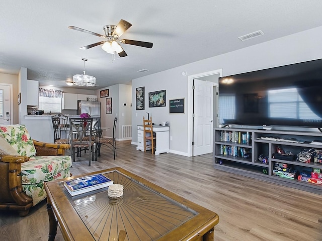1722 Moreno Pl, The Villages, FL 32159 - living area with light wood finished floors, a ceiling fan, healthy amount of natural light, and a chandelier