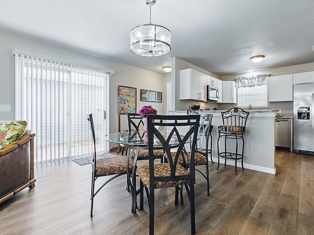 1722 Moreno Pl, The Villages, FL 32159 - dining space featuring wood finished floors, a chandelier, and a textured ceiling