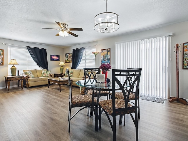 1722 Moreno Pl, The Villages, FL 32159 - dining room with wood finished floors, a ceiling fan, a textured ceiling, and a chandelier