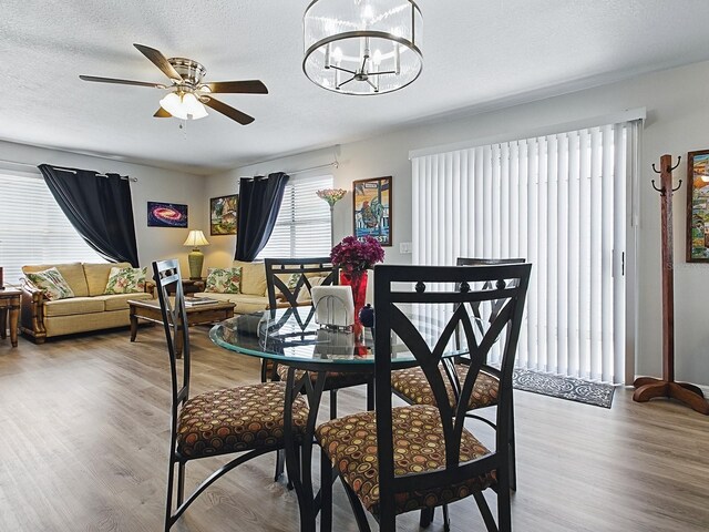 1722 Moreno Pl, The Villages, FL 32159 - dining space with a ceiling fan, wood finished floors, a chandelier, and a textured ceiling