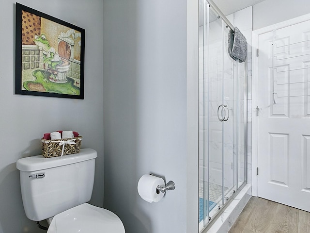 1722 Moreno Pl, The Villages, FL 32159 - bathroom featuring wood finished floors, a shower stall, and toilet