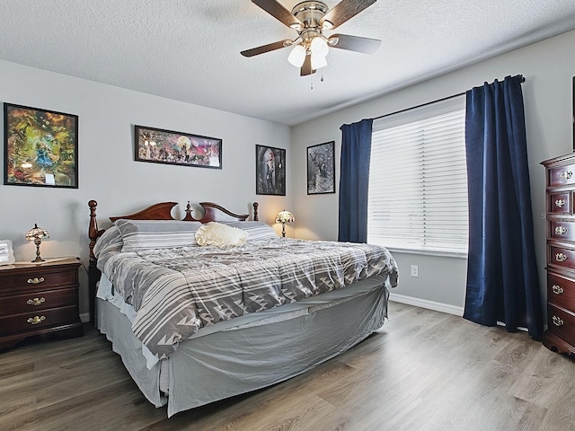 1722 Moreno Pl, The Villages, FL 32159 - bedroom featuring wood finished floors, baseboards, a textured ceiling, and a ceiling fan