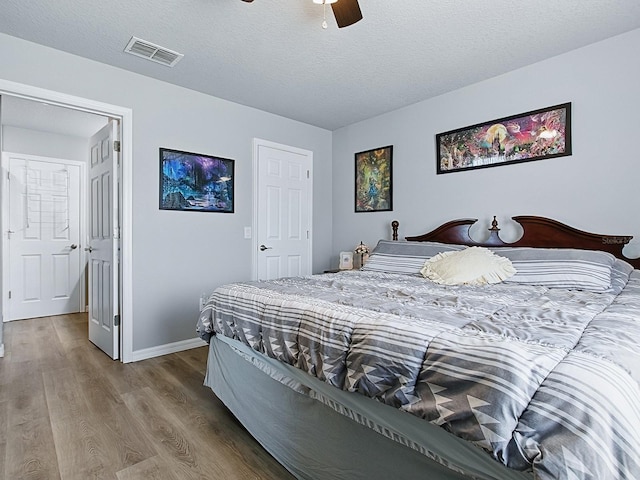 1722 Moreno Pl, The Villages, FL 32159 - bedroom featuring wood finished floors, baseboards, a ceiling fan, and a textured ceiling