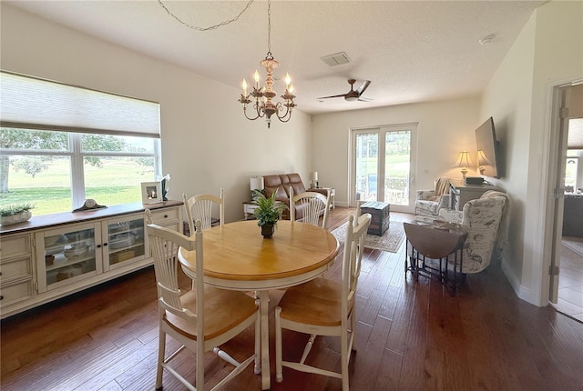 dining space featuring dark wood finished floors, a chandelier, and ceiling fan