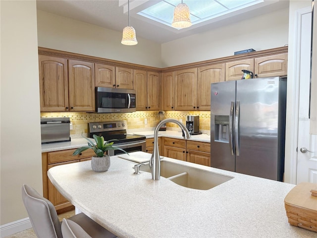 kitchen featuring appliances with stainless steel finishes, a sink, backsplash, and light countertops