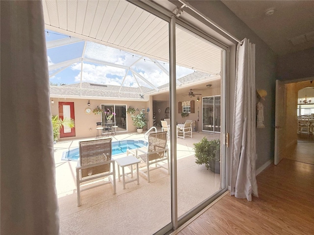 doorway to outside featuring wood finished floors, a sunroom, and lofted ceiling