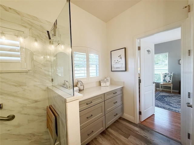 full bathroom with wood finished floors, a shower, and vanity
