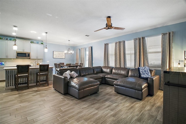 1155 Dora Parc Ln, Mount Dora, FL 32757 - living area with light wood-type flooring, a chandelier, a ceiling fan, and ornamental molding