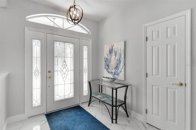 5400 Saddleback Ct, Lady Lake, FL 32159 - foyer with marble finish floors, healthy amount of natural light, a chandelier, baseboards, and a textured ceiling