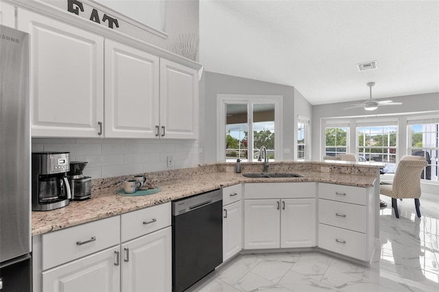 5400 Saddleback Ct, Lady Lake, FL 32159 - kitchen featuring dishwashing machine, a sink, freestanding refrigerator, light marble finish floors, and a peninsula