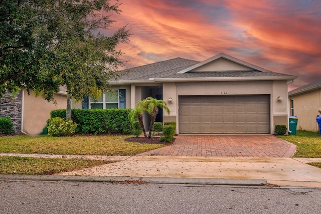 3194 Bayou Ln, Tavares, FL 32778 - view of front facade featuring decorative driveway, stucco siding, a garage, and a front lawn