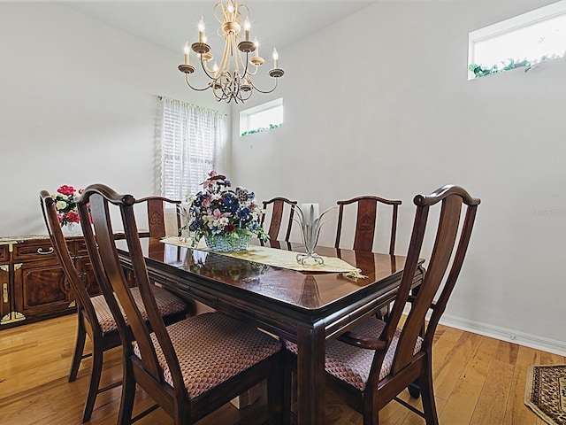 dining room with a chandelier, light wood-style floors, and baseboards