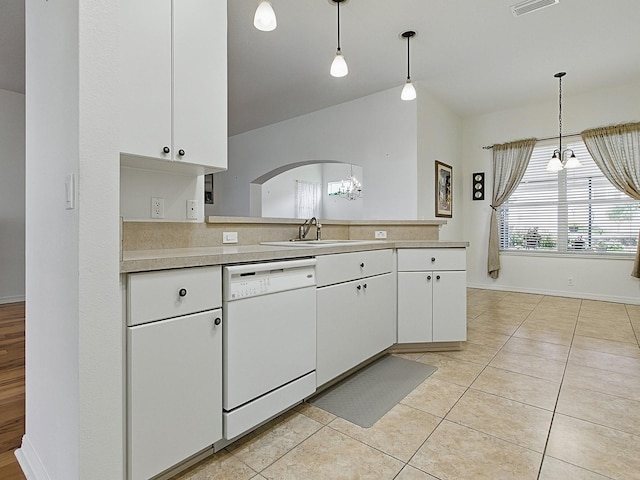 kitchen with white dishwasher, a sink, a chandelier, light countertops, and hanging light fixtures