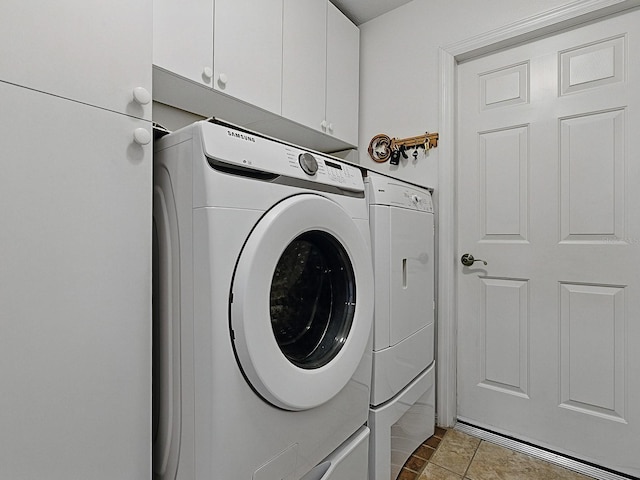 laundry room with cabinet space, separate washer and dryer, and tile patterned flooring