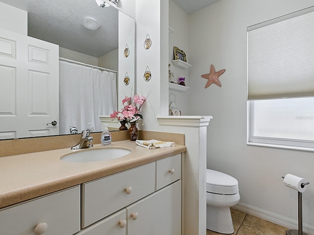 bathroom with toilet, vanity, tile patterned floors, and baseboards