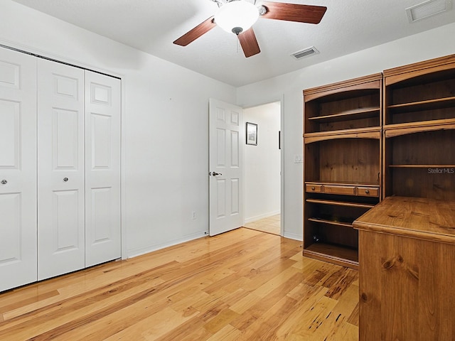 unfurnished bedroom with light wood-type flooring, ceiling fan, baseboards, and a closet