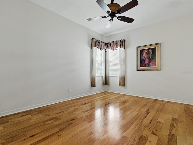 unfurnished room with baseboards, light wood-type flooring, and a ceiling fan