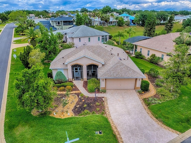 view of front of property with an attached garage, stucco siding, concrete driveway, a residential view, and a shingled roof