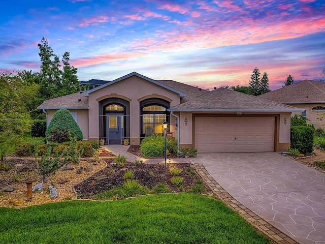 single story home featuring stucco siding, an attached garage, and driveway