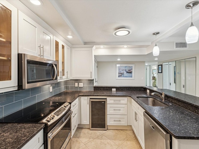 kitchen with beverage cooler, a sink, stainless steel appliances, white cabinetry, and tasteful backsplash
