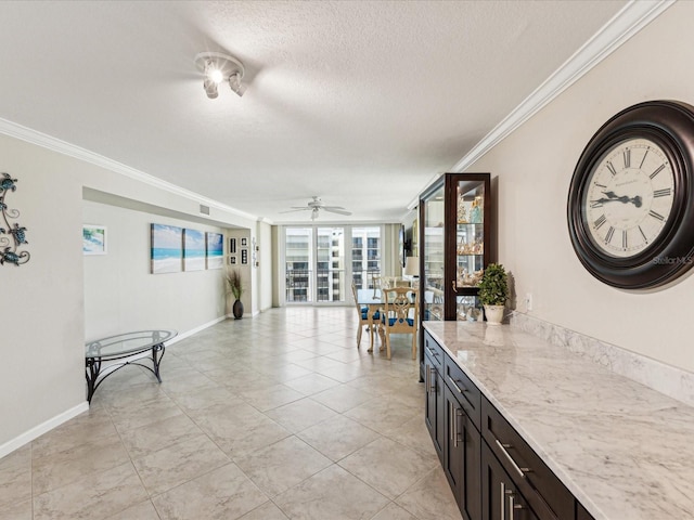 corridor with crown molding, a textured ceiling, baseboards, and light tile patterned floors