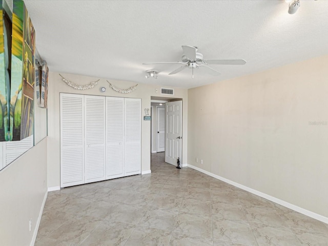 unfurnished bedroom featuring baseboards, a closet, a textured ceiling, and a ceiling fan