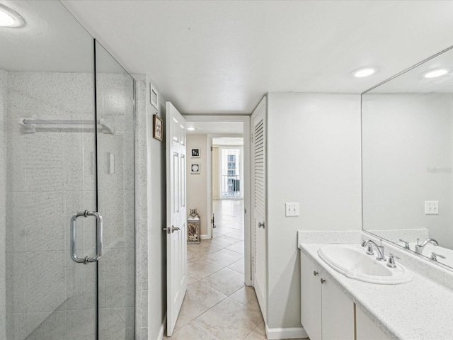 bathroom featuring tile patterned floors, a stall shower, vanity, and baseboards