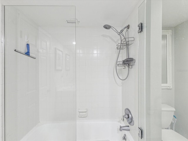bathroom with bathing tub / shower combination and toilet