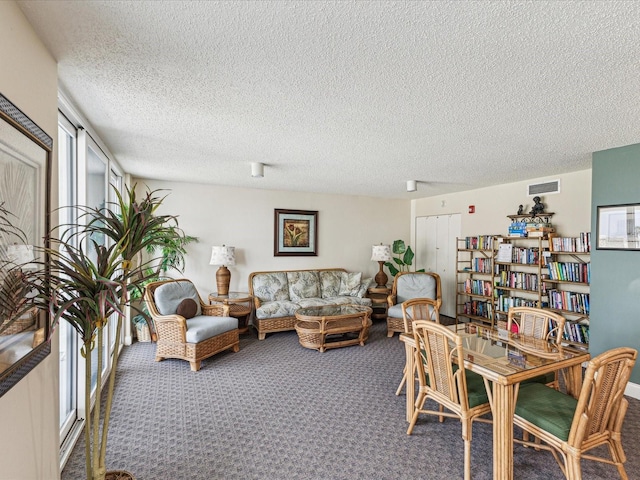 carpeted dining area with a textured ceiling