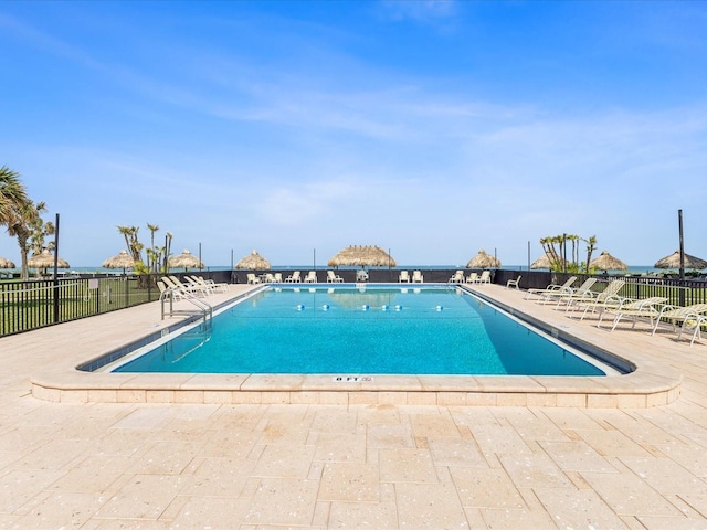 community pool with fence and a patio