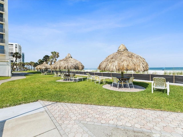 surrounding community featuring a water view, a yard, a patio area, and outdoor dining area