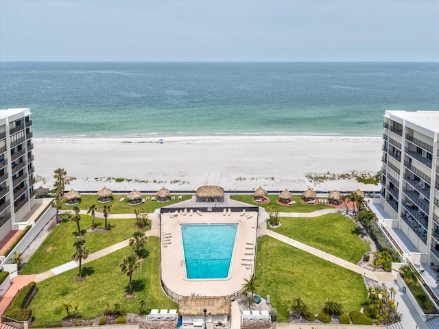 drone / aerial view of waterfront with a beach and a pool area