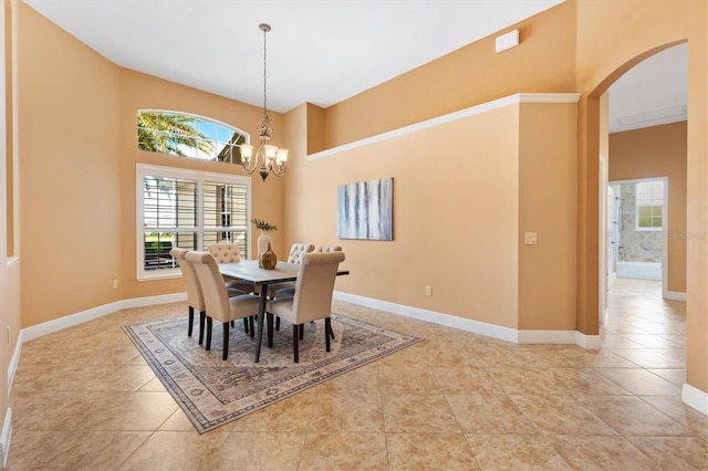 1123 Barnacle Ter, The Villages, FL 32162 - dining area featuring arched walkways, a chandelier, light tile patterned floors, baseboards, and a high ceiling