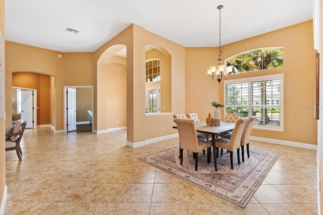 1123 Barnacle Ter, The Villages, FL 32162 - dining area featuring a chandelier, arched walkways, baseboards, and light tile patterned floors