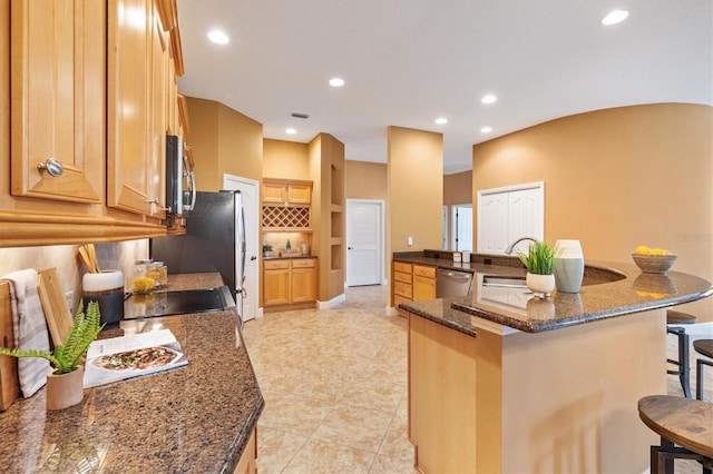 1123 Barnacle Ter, The Villages, FL 32162 - kitchen featuring stainless steel appliances, a kitchen bar, recessed lighting, tasteful backsplash, and a large island