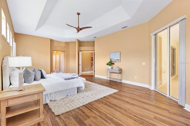 1123 Barnacle Ter, The Villages, FL 32162 - bedroom with a tray ceiling, light wood finished floors, baseboards, and ceiling fan