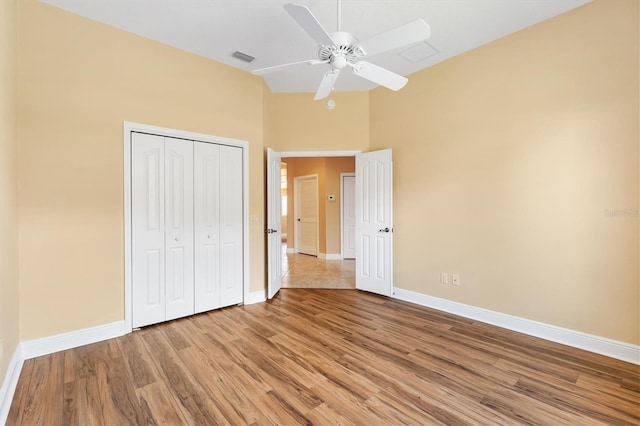 1123 Barnacle Ter, The Villages, FL 32162 - unfurnished bedroom featuring baseboards, light wood-style flooring, a closet, a high ceiling, and a ceiling fan