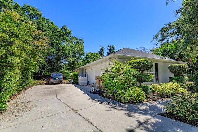 11442 Beggs Ct, Clermont, FL 34711 - view of property exterior featuring driveway, stucco siding, and an attached garage