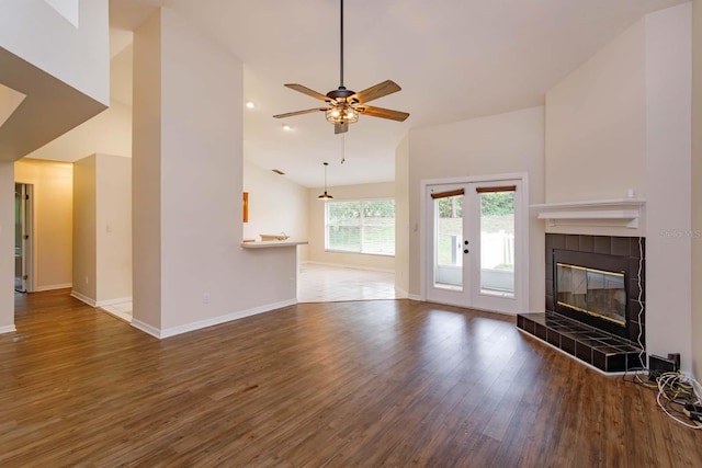 11442 Beggs Ct, Clermont, FL 34711 - unfurnished living room featuring wood finished floors, baseboards, a tiled fireplace, ceiling fan, and lofted ceiling