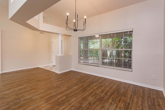 11442 Beggs Ct, Clermont, FL 34711 - unfurnished dining area with a chandelier, wood finished floors, baseboards, and decorative columns
