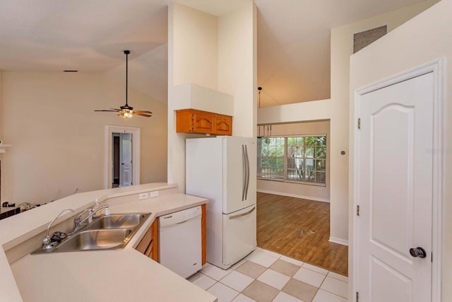 11442 Beggs Ct, Clermont, FL 34711 - kitchen featuring white appliances, a sink, brown cabinetry, light countertops, and high vaulted ceiling