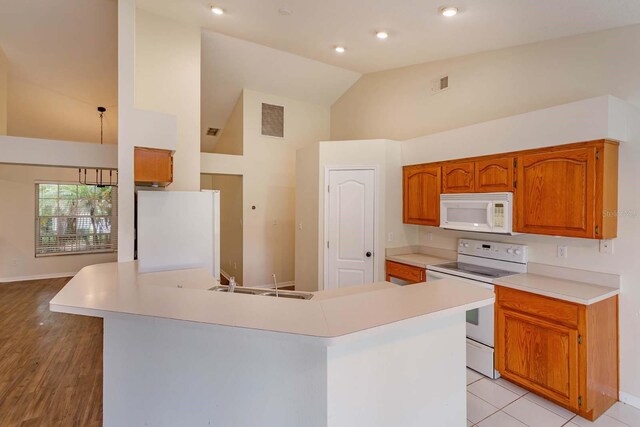 11442 Beggs Ct, Clermont, FL 34711 - kitchen featuring white appliances, high vaulted ceiling, a sink, light countertops, and baseboards