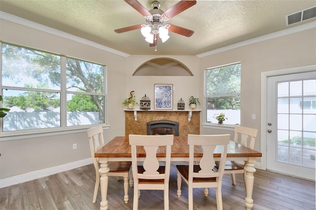 3732 Fallscrest Cir, Clermont, FL 34711 - dining area with a textured ceiling, light wood finished floors, a fireplace, ceiling fan, and baseboards