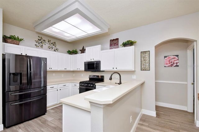 3732 Fallscrest Cir, Clermont, FL 34711 - kitchen featuring refrigerator with ice dispenser, gas stove, black microwave, a sink, and a peninsula