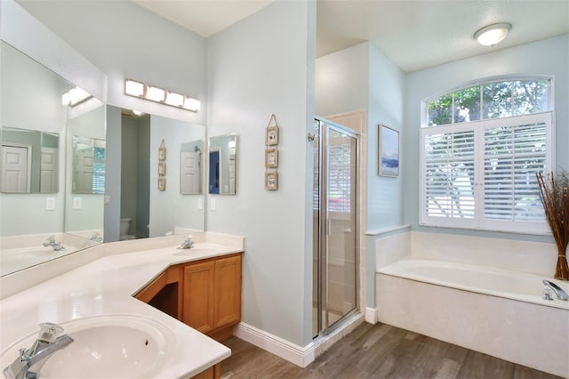 3732 Fallscrest Cir, Clermont, FL 34711 - full bathroom with wood finished floors, a stall shower, a bath, double vanity, and toilet