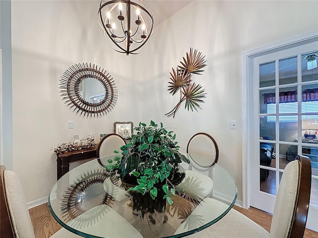dining room with baseboards, a chandelier, and wood finished floors