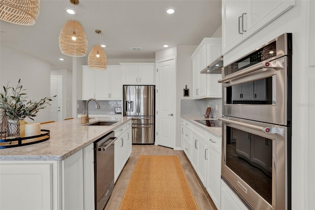 kitchen featuring stainless steel appliances, a sink, exhaust hood, tasteful backsplash, and recessed lighting
