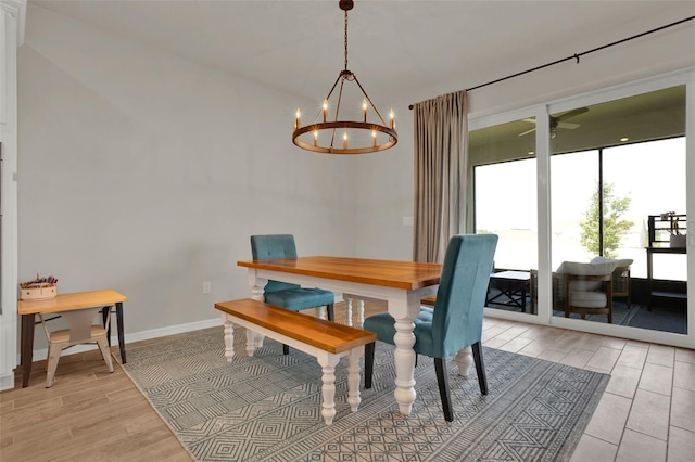 dining area featuring a chandelier, light wood-type flooring, baseboards, and a ceiling fan