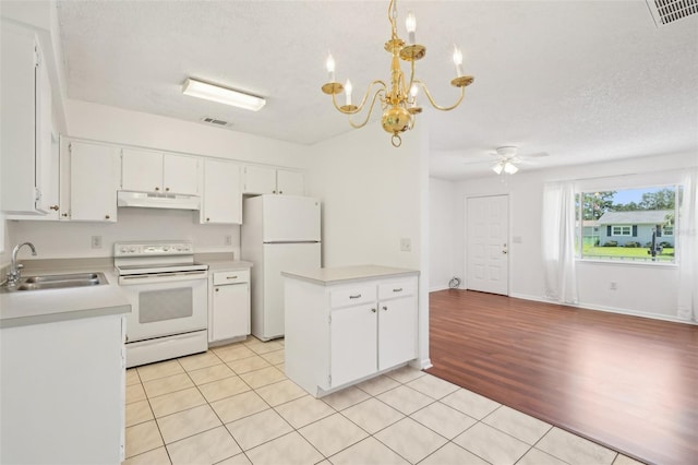 11214 SW 77th Ct, Ocala, FL 34476 - kitchen with white appliances, under cabinet range hood, a sink, light countertops, and a chandelier